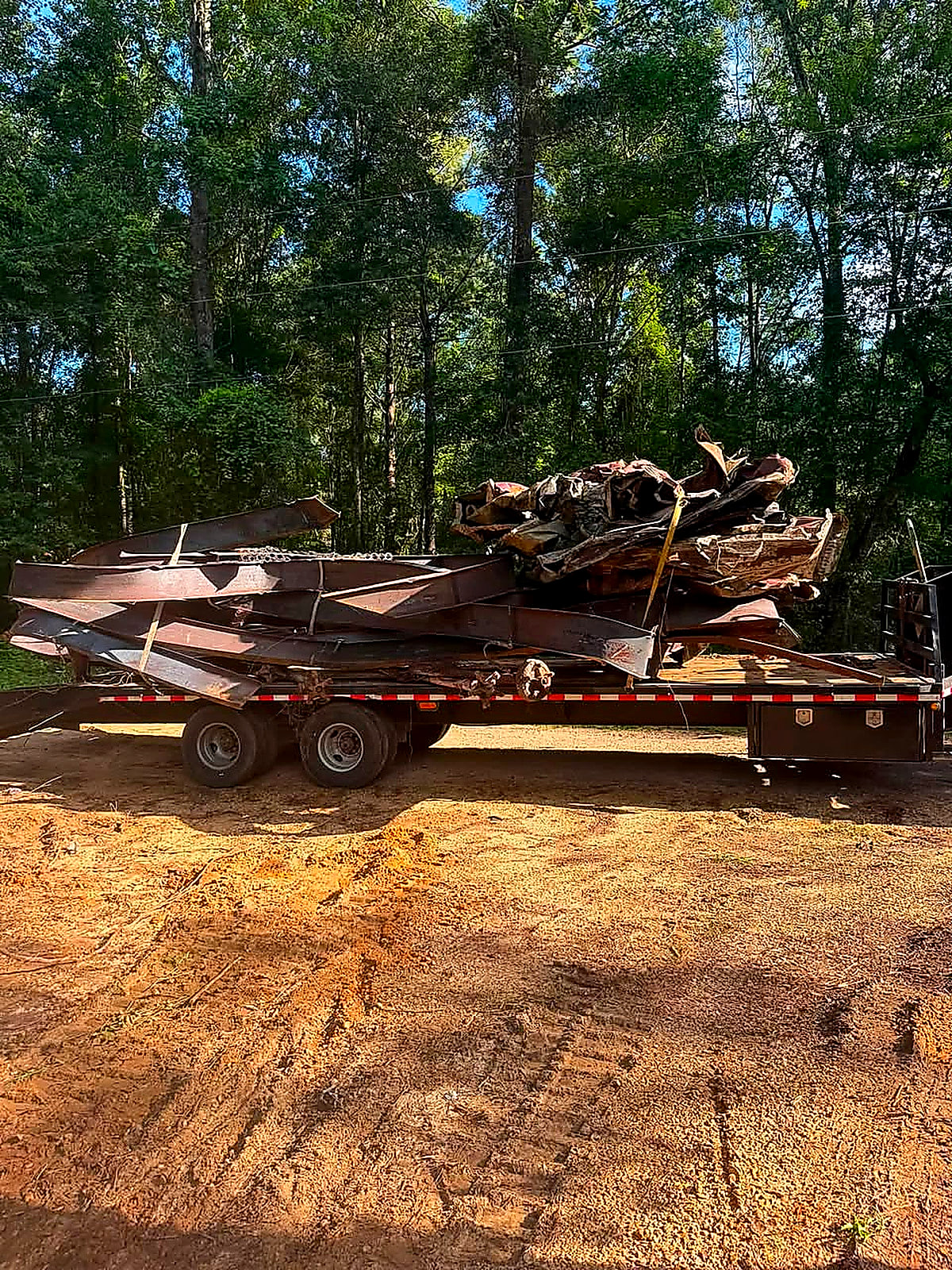 The same field scraped back to bare ground with the metal loaded on the trailer